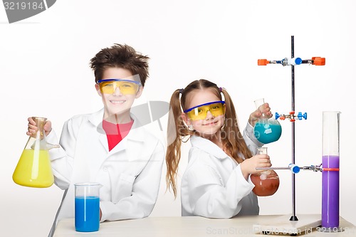 Image of Two cute children at chemistry lesson making experiments