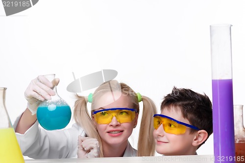Image of Teen and teacher of chemistry at  lesson making experiments