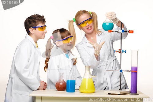 Image of Teens and teacher of chemistry at  lesson making experiments