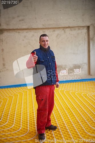 Image of workers installing underfloor heating system