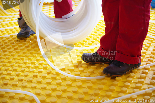 Image of workers installing underfloor heating system