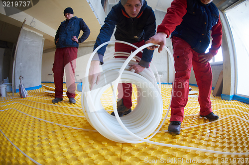 Image of workers installing underfloor heating system