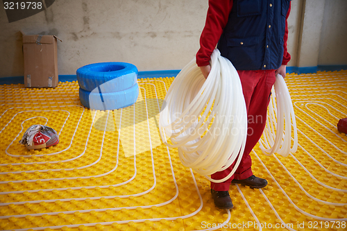 Image of workers installing underfloor heating system