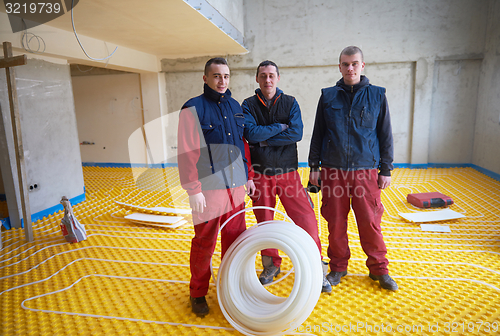 Image of workers installing underfloor heating system