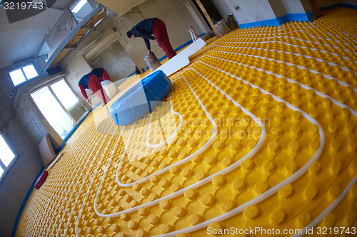 Image of workers installing underfloor heating system