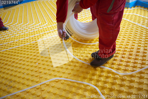 Image of workers installing underfloor heating system