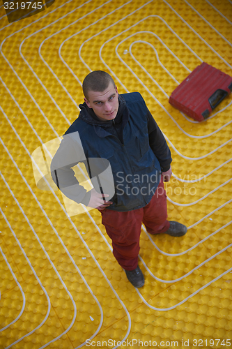 Image of workers installing underfloor heating system