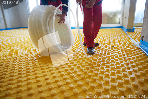 Image of workers installing underfloor heating system