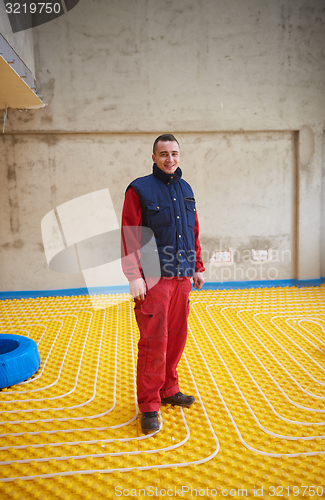 Image of workers installing underfloor heating system