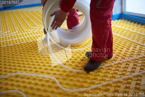 Image of workers installing underfloor heating system