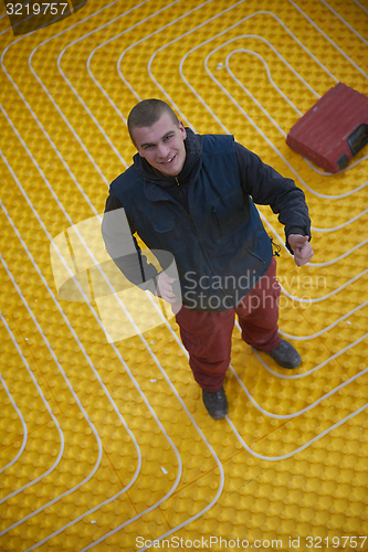 Image of workers installing underfloor heating system