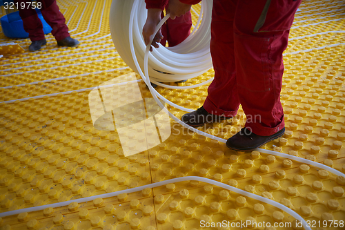 Image of workers installing underfloor heating system