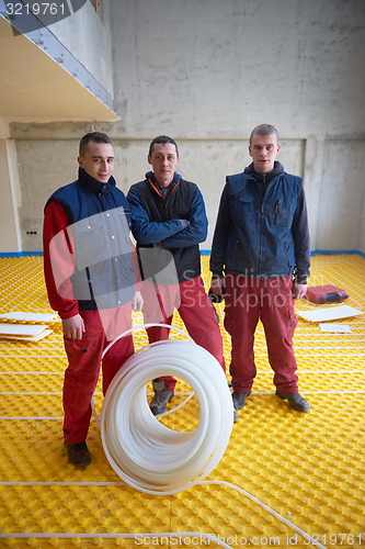 Image of workers installing underfloor heating system