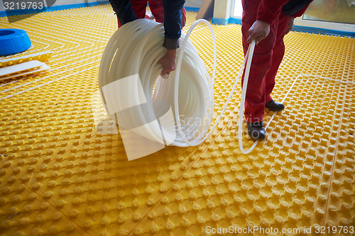 Image of workers installing underfloor heating system