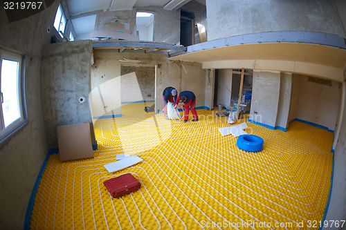 Image of workers installing underfloor heating system