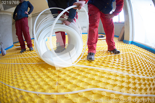 Image of workers installing underfloor heating system