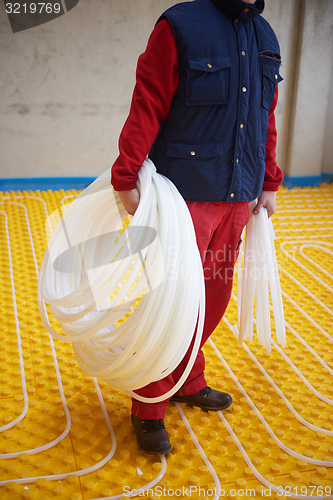 Image of workers installing underfloor heating system