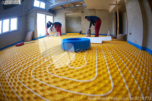 Image of workers installing underfloor heating system