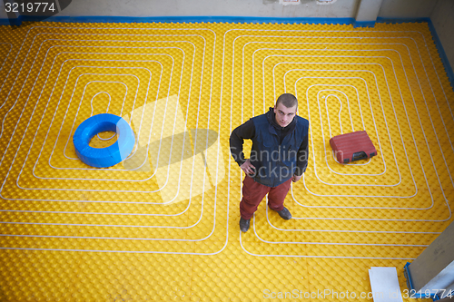 Image of workers installing underfloor heating system