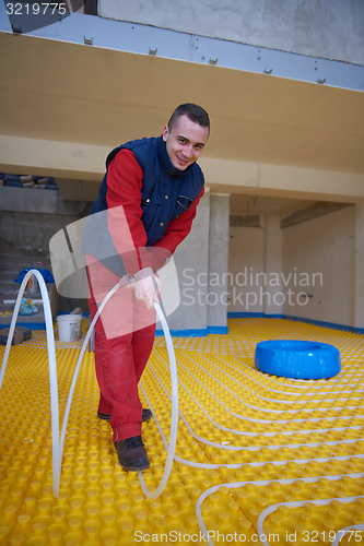 Image of workers installing underfloor heating system