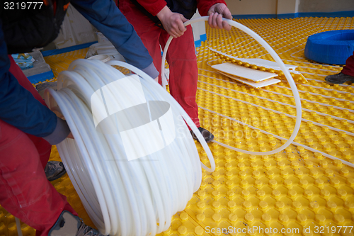 Image of workers installing underfloor heating system