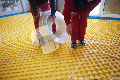 Image of workers installing underfloor heating system