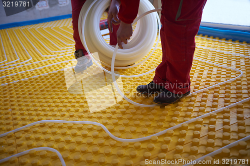 Image of workers installing underfloor heating system