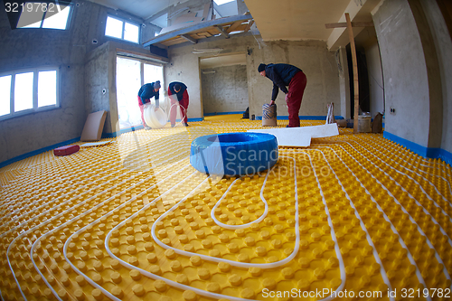 Image of workers installing underfloor heating system