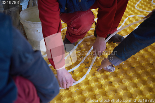 Image of workers installing underfloor heating system