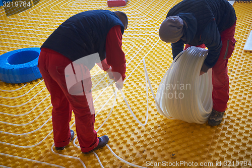 Image of workers installing underfloor heating system