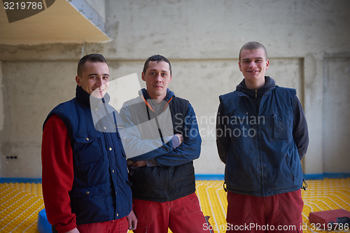 Image of workers installing underfloor heating system