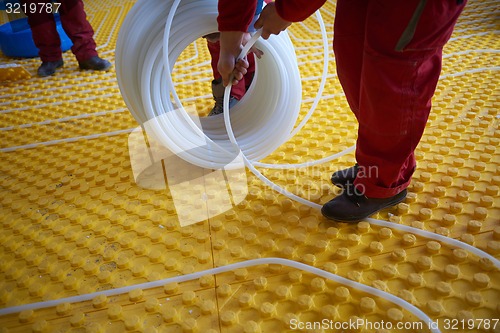 Image of workers installing underfloor heating system