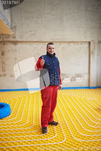 Image of workers installing underfloor heating system