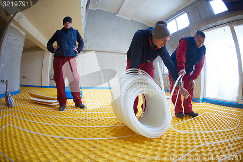 Image of workers installing underfloor heating system