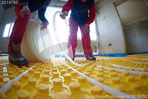 Image of workers installing underfloor heating system