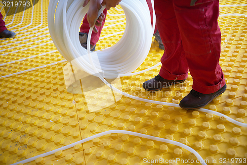 Image of workers installing underfloor heating system