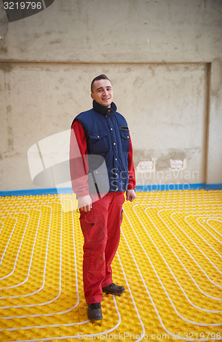 Image of workers installing underfloor heating system