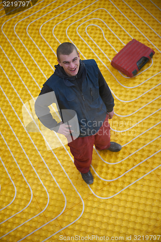 Image of workers installing underfloor heating system