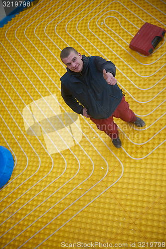 Image of workers installing underfloor heating system