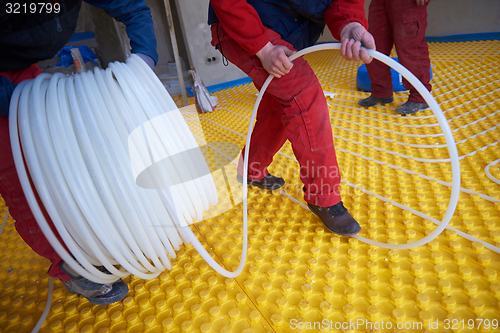 Image of workers installing underfloor heating system