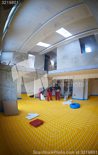 Image of workers installing underfloor heating system