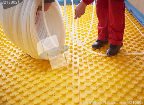 Image of workers installing underfloor heating system