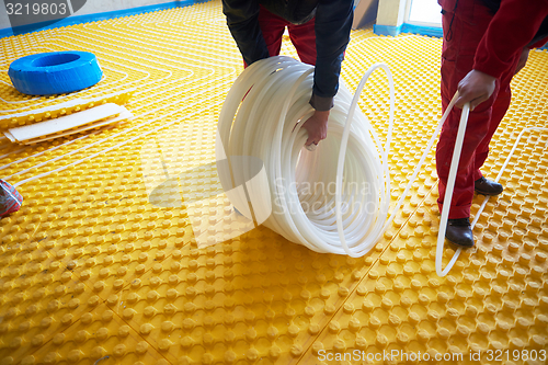 Image of workers installing underfloor heating system