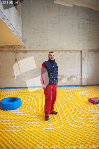 Image of workers installing underfloor heating system