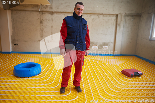 Image of workers installing underfloor heating system