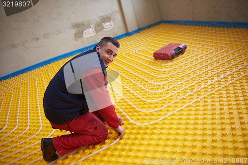 Image of workers installing underfloor heating system