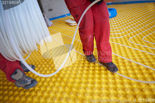 Image of workers installing underfloor heating system