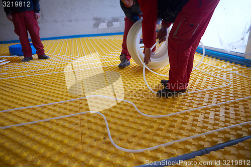 Image of workers installing underfloor heating system