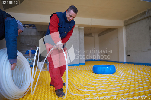 Image of workers installing underfloor heating system