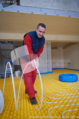 Image of workers installing underfloor heating system